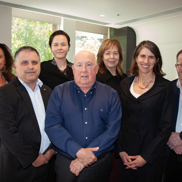 Colleagues gathered together smiling at camera following their meeting