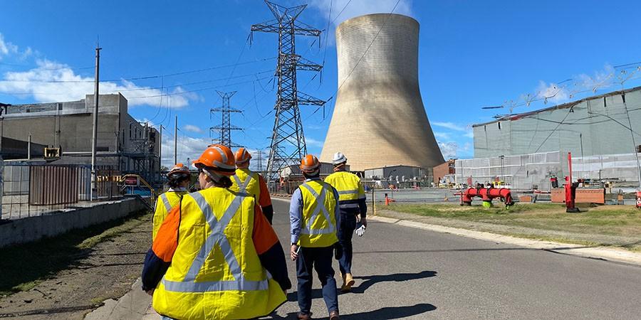 Workers in high-vis safety gear on the road at a power station