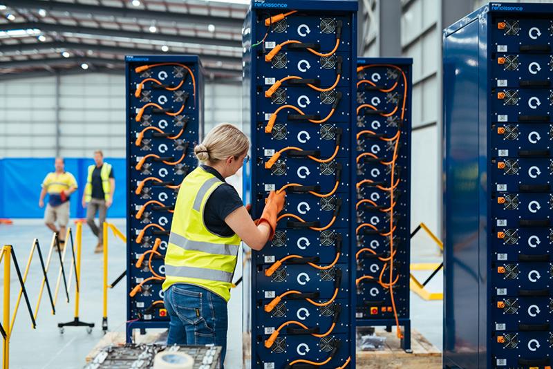 Technician works with stack of navy blue lithium batteries