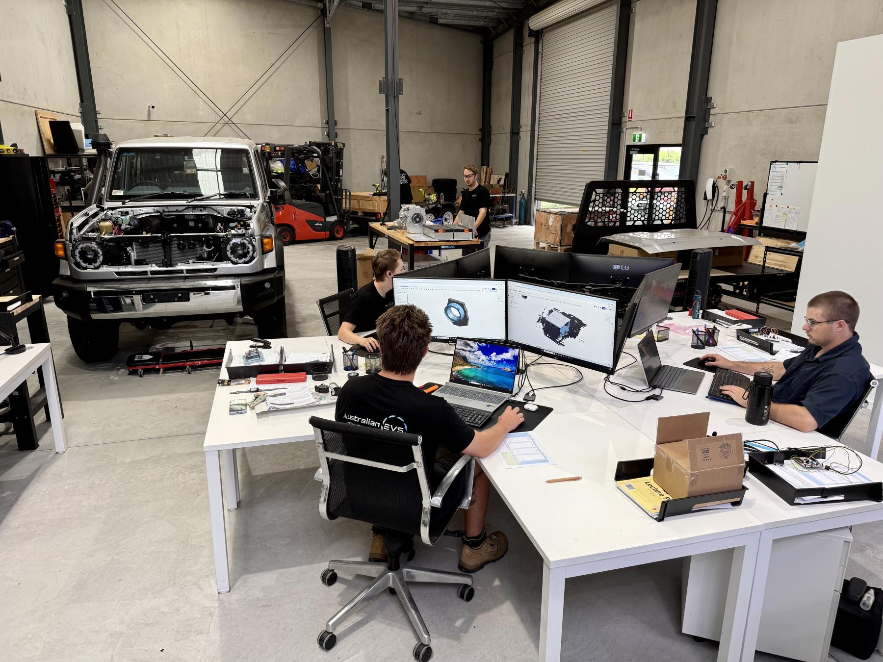 People in an open plan office with a vehicle in the background