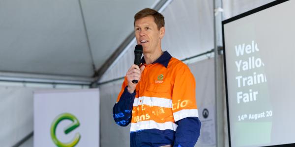 Energy Australia's CEO standing with a microphone