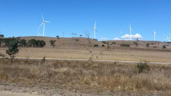 wind turbines standing in an open field.