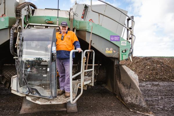 A worker for Gippsland Regional Organics, on a waste processing machine