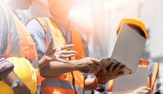 Engineers having a discussion with laptop in hand