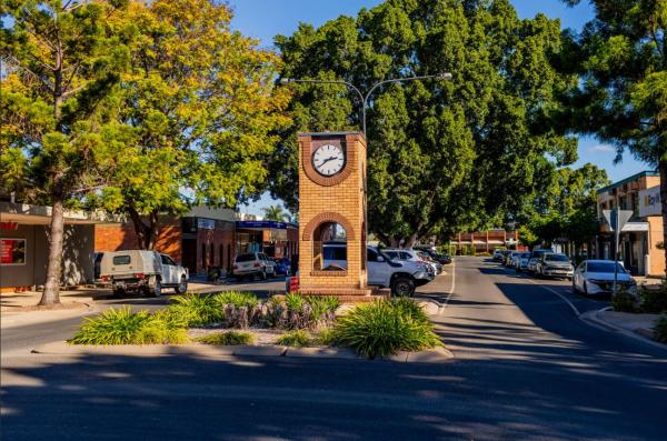 Main street of Emerald, Qld. A regional town street, with a clock tower at the intersection and pleasant green trees