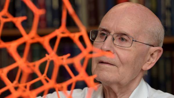 Professor Richard Robson next to an orange structure model