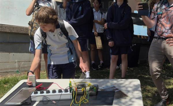 Schoolchild interacting with an educative solar panel display
