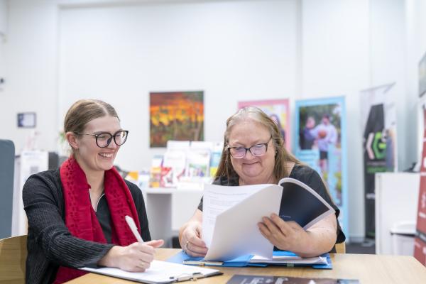 Two women look at paperwork and plans at the jobs centre