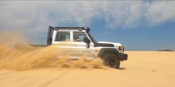 A landcruiser driving on sand dunes
